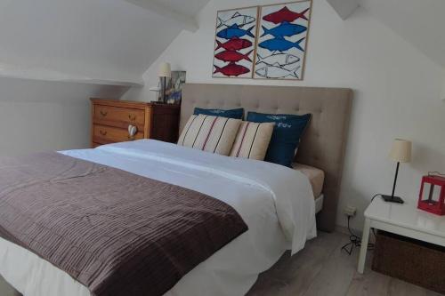 une chambre avec un lit et une commode dans l'établissement Maison de charme avec piscine, à Clohars-Carnoët