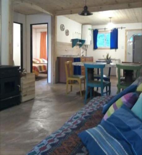 ein Wohnzimmer mit einem Tisch und Stühlen sowie eine Küche in der Unterkunft La Rosadita in Necochea