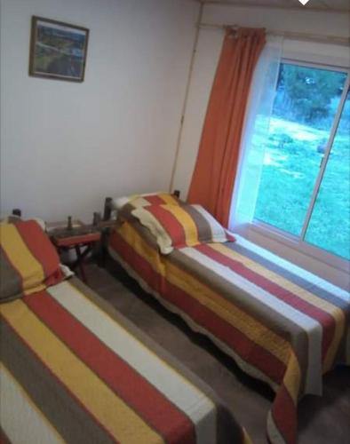 Duas camas num quarto com uma janela em La Rosadita em Necochea