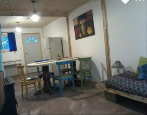 um quarto com uma mesa e cadeiras e uma cama em La Rosadita em Necochea