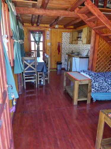a living room with a wooden floor and a kitchen at Portal de La Quebrada in Las Chacras
