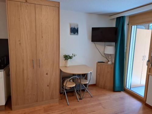 a room with a table and a cupboard and a small table at Haus Vitalis in Zermatt
