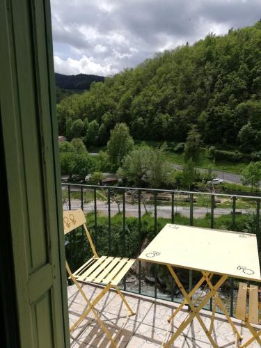 a table and a chair on a balcony with a view at T2 petite terrasse coeur de ville in Prats-de-Mollo-la-Preste