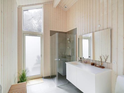 a bathroom with a white sink and a mirror at Holiday home Hundested XI in Hundested