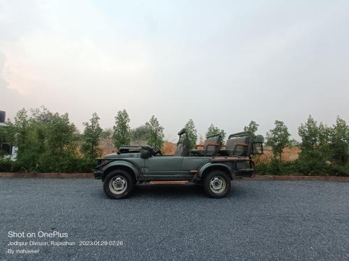 an old green car parked in a parking lot at Jawai Empire Resort by Premier Hotels in Pāli