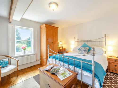 a bedroom with a bed and a chair and a window at Hollow Creek Cottage - 28012 in Rockcliffe