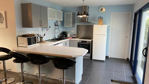 Il comprend une cuisine équipée d'un comptoir et d'un réfrigérateur blanc. dans l'établissement Maison 6 personnes, 3 chambres, près de la mer, au calme, à Riantec