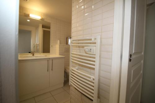 La salle de bains blanche est pourvue d'un lavabo et d'un miroir. dans l'établissement Moulins Studio cœur de ville de Saint Dizier, à Saint-Dizier