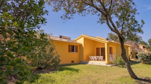 a view of a yellow house with a yard at Residence Mare e Sole in Taglio-Isolaccio