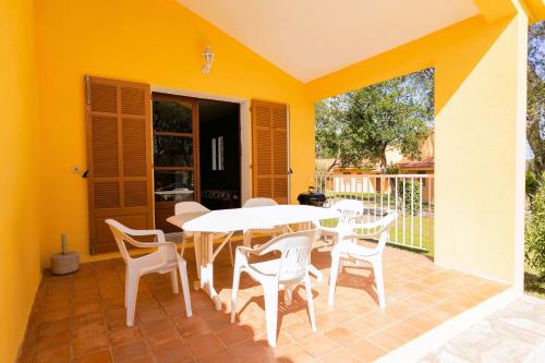 a patio with a white table and chairs on a patio at Residence Mare e Sole in Taglio-Isolaccio