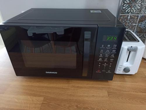 a black microwave oven sitting on top of a table at Diana's Penthouse in Perea