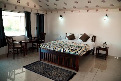 a bedroom with a bed with a table and chairs at Jawai Empire Resort by Premier Hotels in Pāli