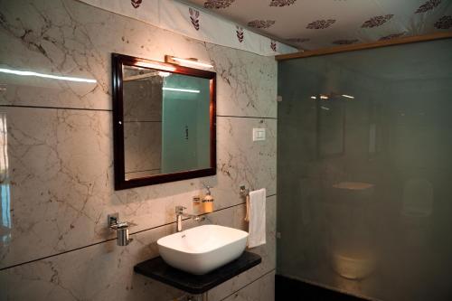 a bathroom with a sink and a mirror at Jawai Empire Resort by Premier Hotels in Pāli