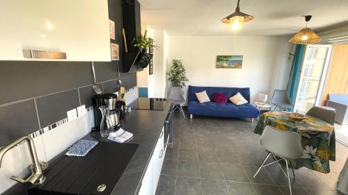 a kitchen and living room with a blue couch at Marguerite-Gap Centre in Gap