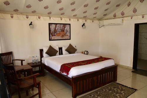 a bedroom with a bed and a table and chairs at Jawai Empire Resort by Premier Hotels in Pāli