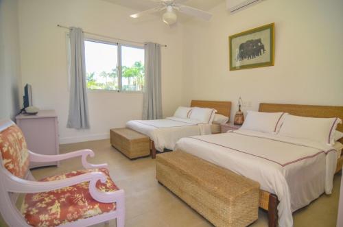1 dormitorio con 2 camas, silla y ventana en Six Bedrooms Luxury Disco Room Villa, en La Romana