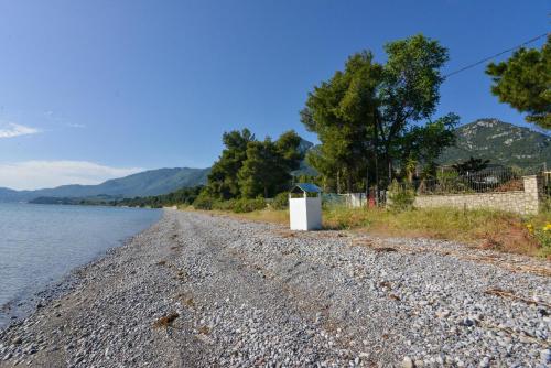 a gravel road next to a body of water at Agios Konstantinos peaceful Beach 3bdr apartment in Agios Konstantinos Fthiotida