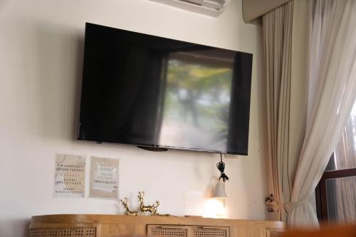 a flat screen tv hanging on a wall at Sunset Villas Palauig Zambales in Palauig