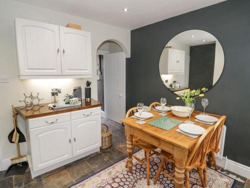 a kitchen with a wooden table and a mirror at Dobbies Den in Bewdley