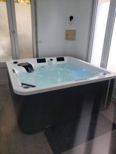 a black and white bath tub in a room at La Casa des Frangins in Saint-Romain-de-Colbosc