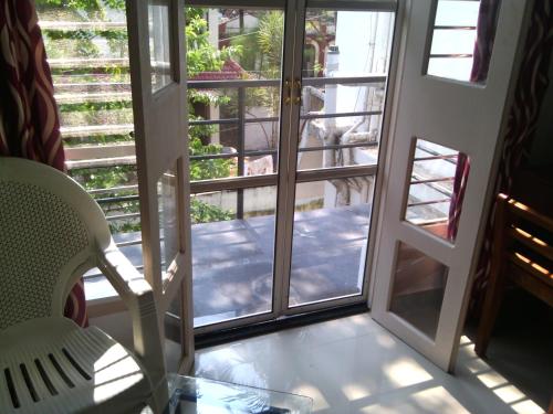 an open door to a balcony with a table and chairs at Nathans Holiday Home in Cochin