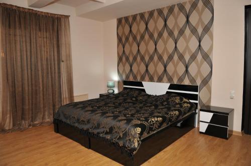 1 dormitorio con cama negra y pared en Nino Duplex Apartment, en Tiflis