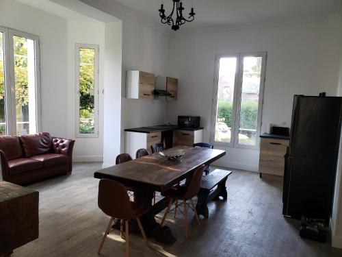 un salon avec une table et des chaises en bois dans l'établissement La Casa des Frangins, à Saint-Romain-de-Colbosc