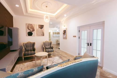 a living room with a blue couch and chairs at Phoenix Luxury Apartments in Abuja