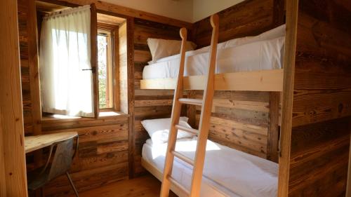 two bunk beds in a log cabin with a window at Agribed Quierta - Camerette 