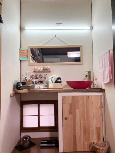a bathroom with a counter with a sink and a mirror at Waraku No2,Guesthouse near KIX in Izumi-Sano