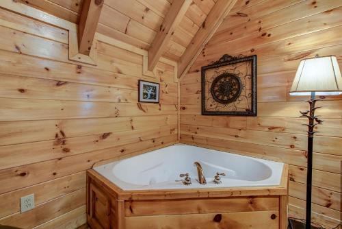 a bath tub in a wooden room with a lamp at Aspen's Envy, 4 Bedrooms, Sleeps 16, Pool Table, Hot Tub, Mountain Views in Pigeon Forge