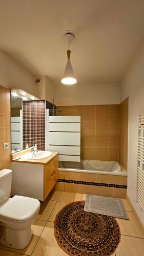 une salle de bain avec toilettes, lavabo et baignoire dans l'établissement Ravissant T3 climatisé 6 personnes, à Sète