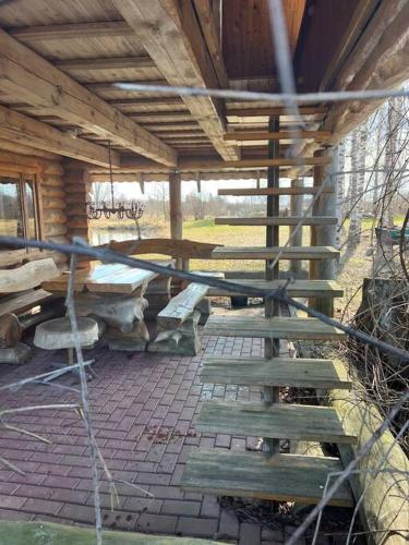 a wooden pavilion with benches and a table at Home of Koknese in Koknese
