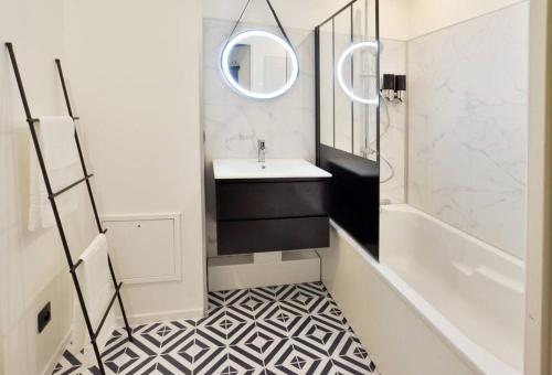 uma casa de banho com um lavatório e um espelho em L'Olivier Disneyland JO Paris 2024 avec Parking em Bailly-Romainvilliers