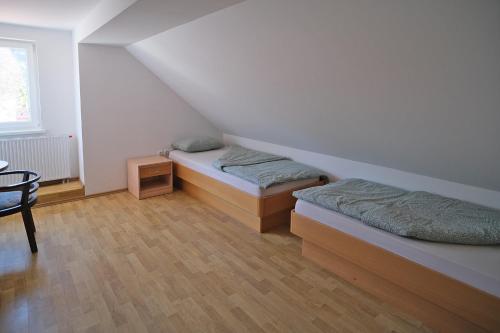 a room with two beds and a table and a window at SOSTANJ VELENJE RAVNE SOBE ROOMS Vrtacnik d o o in Šoštanj