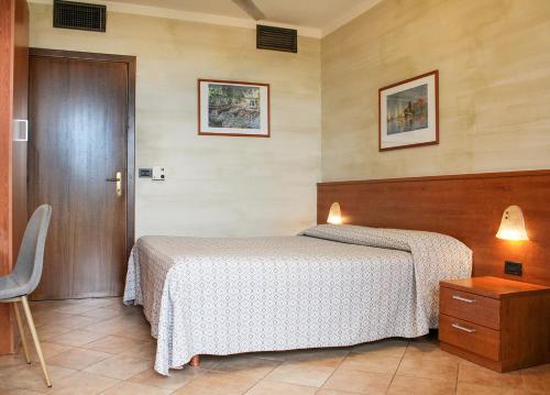 a bedroom with two beds and a wooden door at Hotel Castello S. Antonio in Lazise