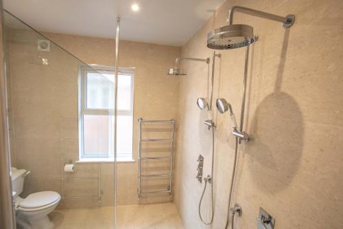 ein Bad mit einer Dusche, einem WC und einer Glastür in der Unterkunft Freshwater House in Freshwater