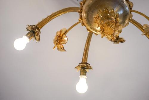 une lampe or avec des lumières au plafond dans l'établissement L'Alberghetto, à Trinità