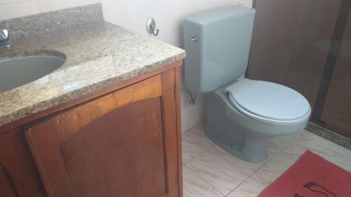 La salle de bains est pourvue de toilettes blanches et d'un lavabo. dans l'établissement CASA DE PRAIA CABO FRIO, à Cabo Frio