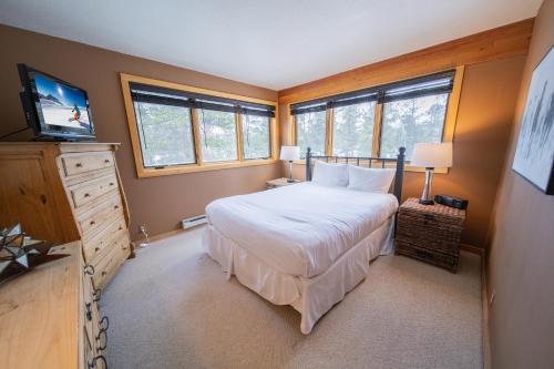 a bedroom with a bed and a tv and windows at Pines 2045 in Keystone