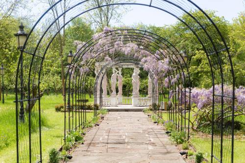 an archway in a garden with purple flowers at Berwick Lodge in Bristol