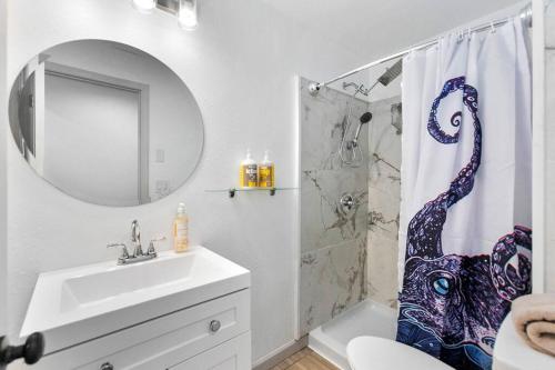 a bathroom with a sink and a shower curtain at Hillside in Seattle - updated and well appointed. in Seattle