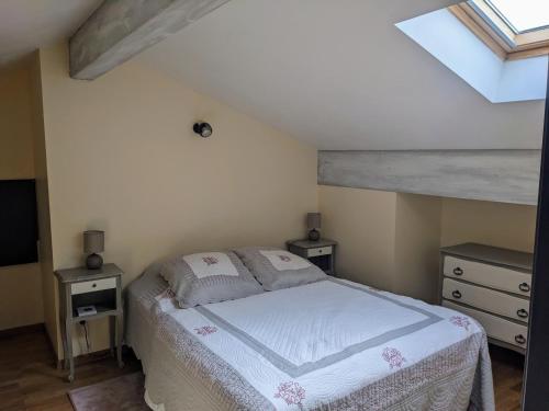 a bedroom with a bed and a skylight at Le gîte astérien in Saint-Astier