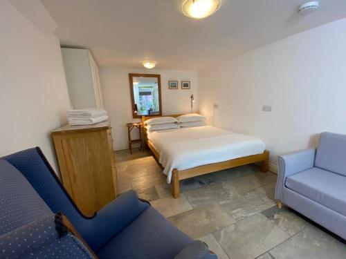 um quarto com uma cama e um sofá azul em Clifton garden flat with parking em Bristol