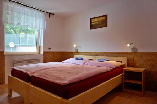 a bedroom with a large bed with a window at Prázdninový dům-Pension ROLIMPEX in Podkopná Lhota