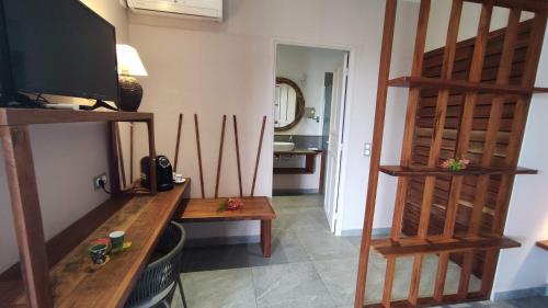 a living room with a television and wooden shelves at Hotel - Résidence Habitation Grande Anse in Deshaies