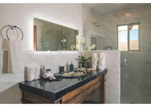 un bagno con lavandino, specchio e doccia di Palazzo del Valle, Alojamiento y Desayuno a Valle de Guadalupe