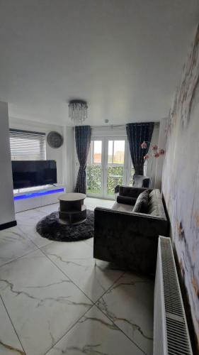 a living room with a couch and a table at Two bed apartment with balcony Slough,Windsor,Legoland in Slough