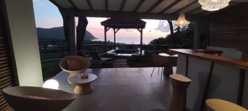 a room with a balcony with a table and chairs at Hotel - Résidence Habitation Grande Anse in Deshaies