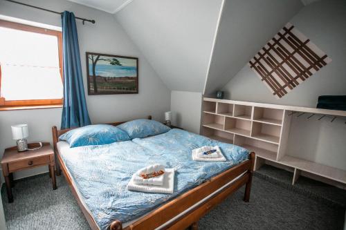 1 dormitorio con 1 cama con toallas en LiBe Apartman, en Gyenesdiás